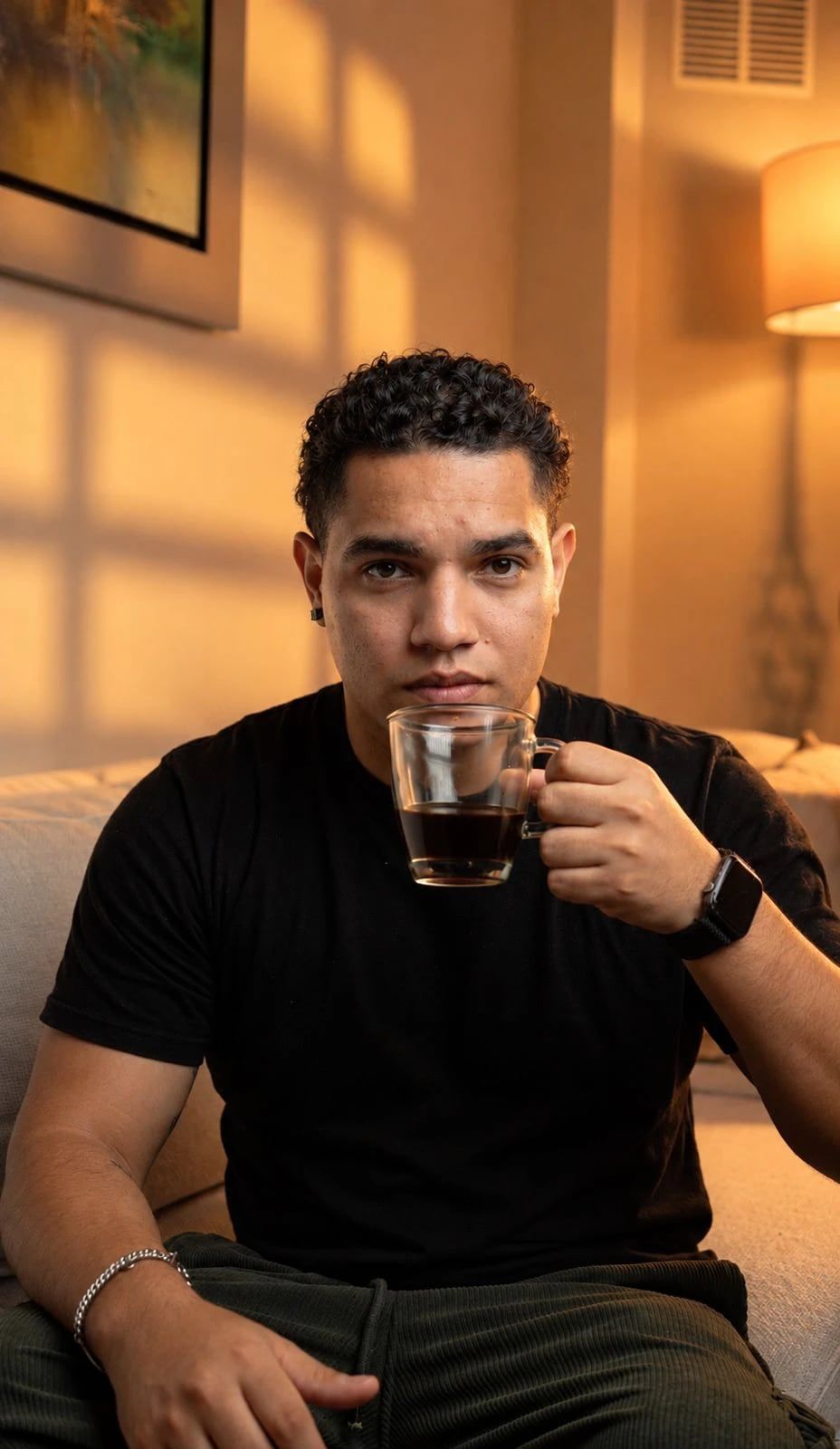 Integrante de VOLTA con una taza de café, sentado en un sofá.