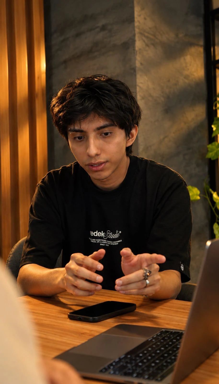 Integrante de VOLTA explica una idea con las manos, frente a su laptop.